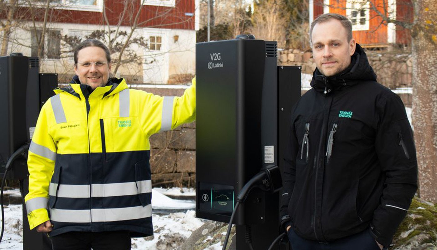 Sven Pålsgård och Rasmus Ekström på Tranås Energi vid en av de dubbelriktade laddarna som möjliggör att de också kan ladda ur bilarnas batterier för att vid behov kunna använda elen någon annanstans. Foto: Tranås Energi