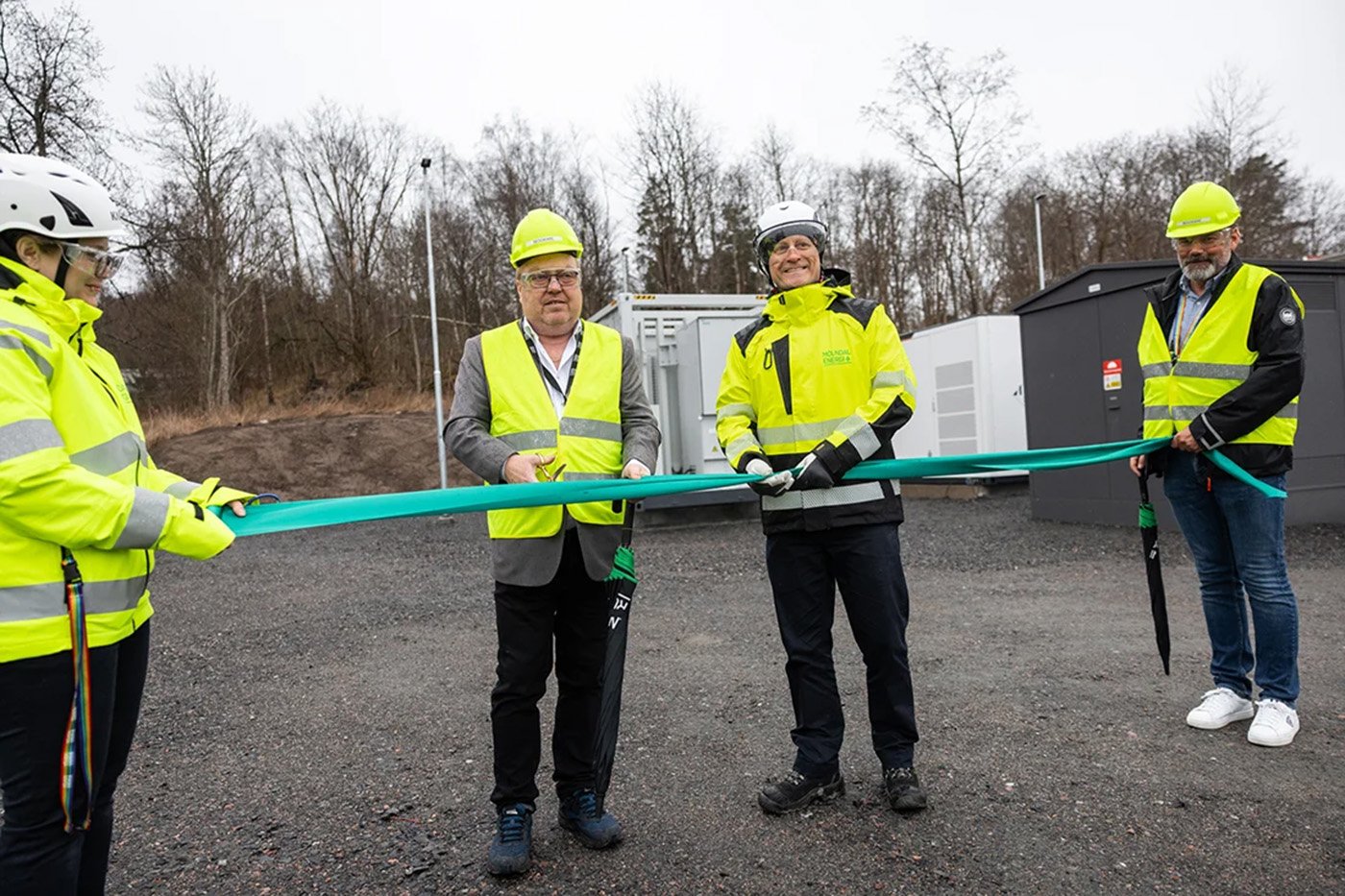 Glada miner n&auml;r batteriparken i M&ouml;lndal invigdes. Kommunstyrelsens ordf&ouml;rande i M&ouml;lndal Stefan Gustafsson och M&ouml;lndal Energis vd Daniel Eklund klipper bandet, med hj&auml;lp av Rebecca Sinnerstedt, kommunikat&ouml;r M&ouml;lndal Energi, och Mattias Sj&ouml;strand, kommunikationschef M&ouml;lndal Energi.   