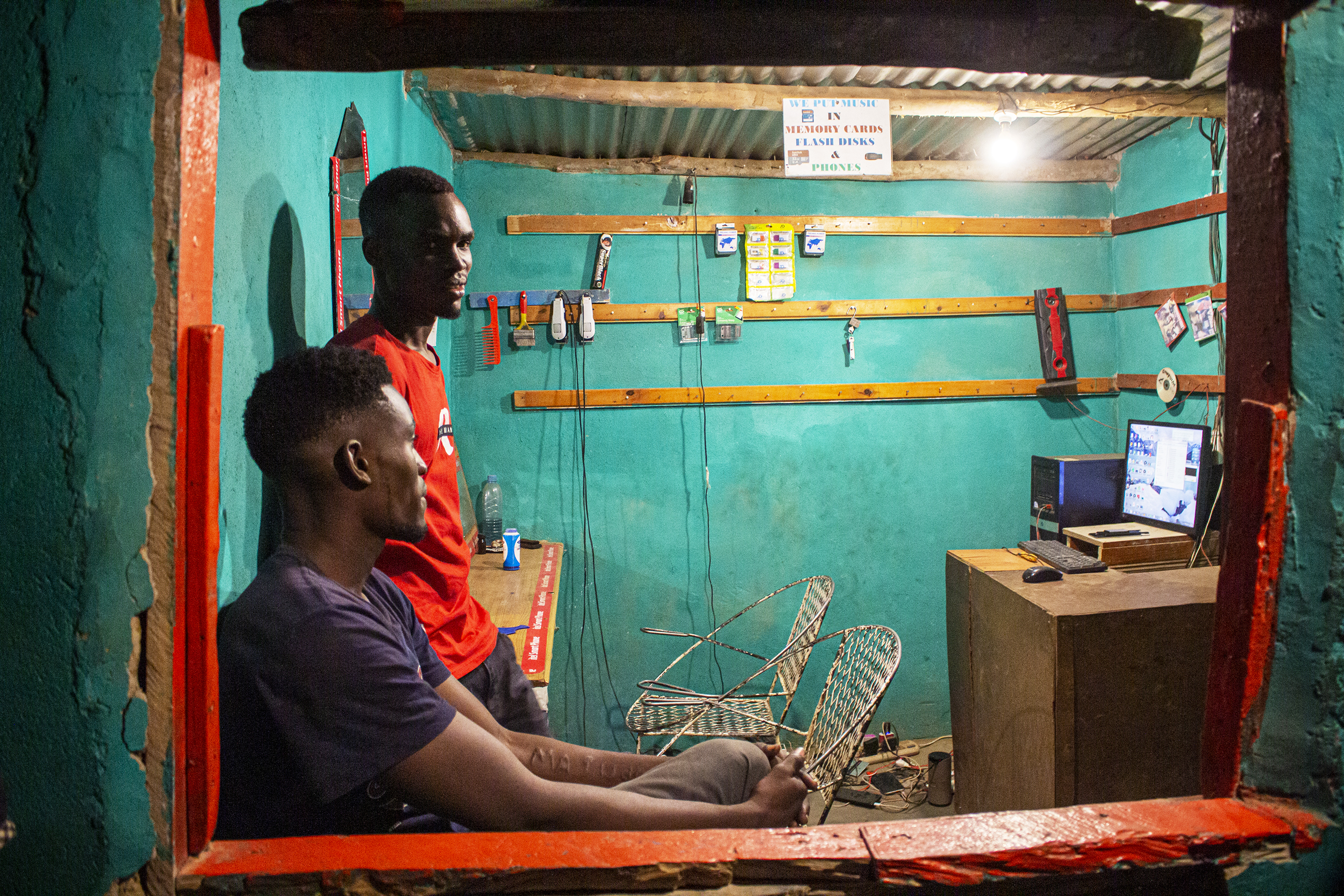 Shadrick Lungu och kusinen Lameck Lungu i Lamecks nyöppnade, kombinerade frisersalong och videobutik -– en affärsrörelse som tidigare var närmast omöjlig att driva i byn.