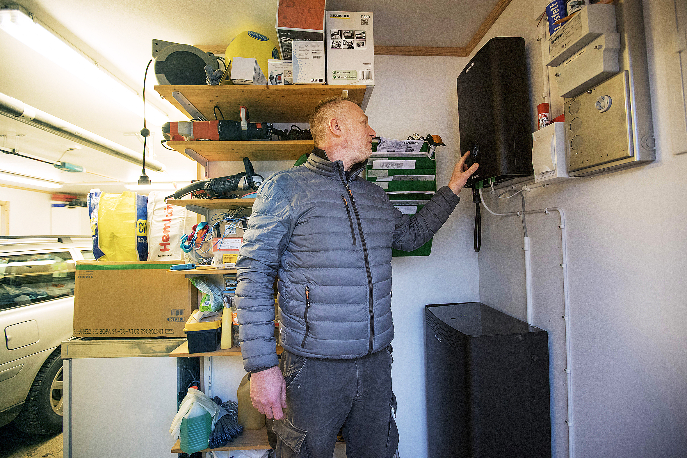 Kristian Jakobsson framför energipaketet i sitt garage: ett batteri på 8 kWh och en energihub som styr elanvändningen.