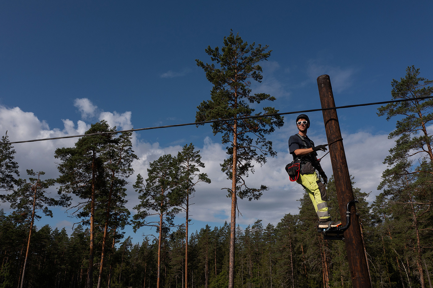 Glenn Toresson klättrar vant upp i stolpen, tio meter upp i luften. Foto: Joachim Grusell.